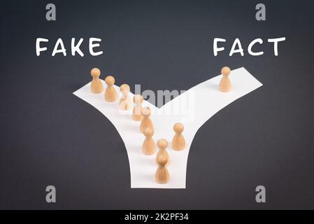 Crowd of people follow the path to the fake information, one thinks different and takes his own way and decisions, propaganda and conspiracy theory concept, media and manipulation issue Stock Photo