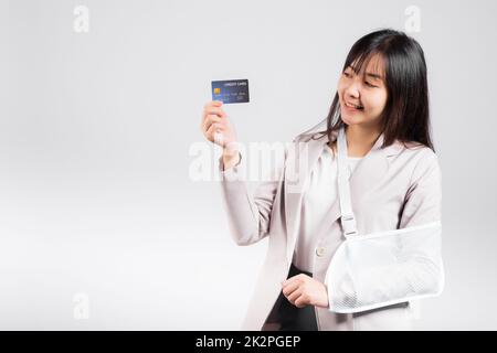 Woman confident smile broken arm after accident and wear arm splint for treatment she emergency pay medical bills by credit card Stock Photo