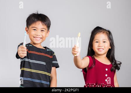 Little cute kid boy and girl 3-6 years old show brush teeth and smile in studio shot isolated Stock Photo