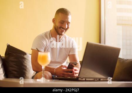 young guy using phone in cafe Stock Photo