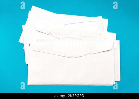 Pile of blank white envelopes on blue background Stock Photo