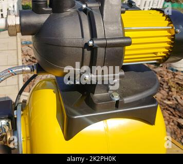 New water pumping station, household automatic station, yellow color, close-up. Application of house, country house, village, cottage Stock Photo