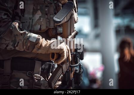 Close-up of a soldier holding modern rifle Stock Photo