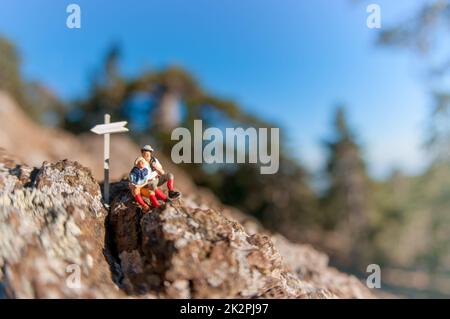 Two hikers with backpack relaxing on top of a mountain Stock Photo