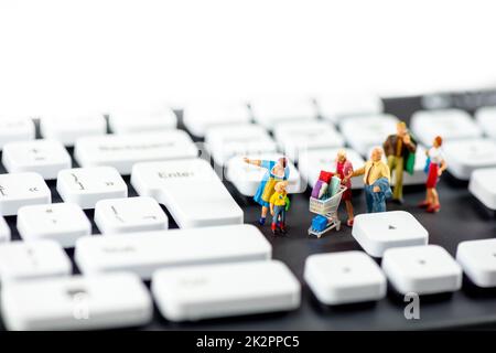 Friendly miniature family looking at computer keyboards. Technology concept Stock Photo