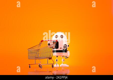 Robot with shopping cart. Contains clipping path Stock Photo