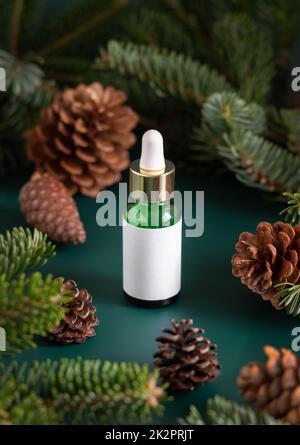 Dropper Bottle near fir branches and pine cones close up. Brand packaging mockup. Stock Photo