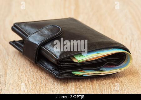 Leather wallet with money on wooden table Stock Photo