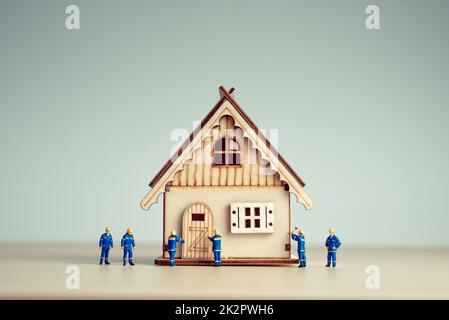 Miniature workers build a new house Stock Photo
