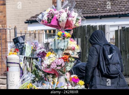 A pupil views floral tributes at the scene in Woodhouse Hill, Huddersfield, where 15-year-old schoolboy Khayri McLean was fatally stabbed outside his school gates. Picture date: Friday September 23, 2022. Stock Photo
