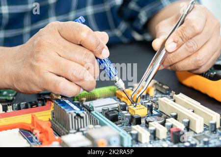 Technician repairing inside of mobile phone by soldering iron. Integrated Circuit. the concept of data, hardware, technology. Stock Photo