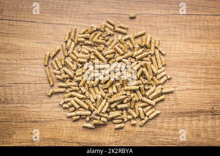 Wooden pellets, biofuel on wooden table. Ecologic fuel made from biomass. Renewable energy source. Stock Photo