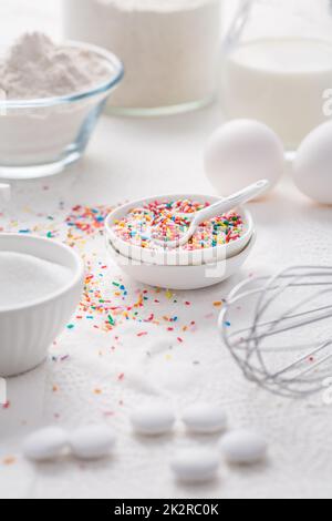 Baking background with flour, eggs, sugar sprinkles, kitchen tools, utensils Stock Photo