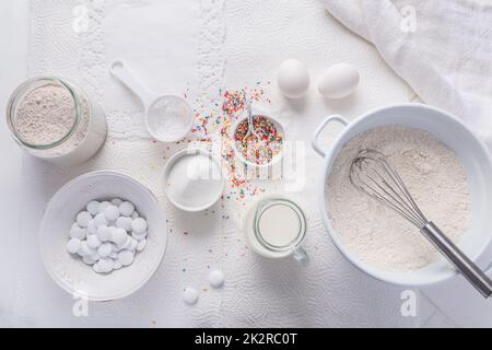 Baking background with flour, eggs, sugar sprinkles, kitchen tools, utensils Stock Photo