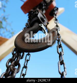 Old rusty hook on blue sky background. Construction industry. Stock Photo