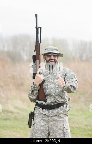 hunter with gun showing thumbs up Stock Photo