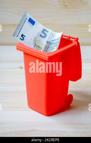 Euro banknote in a garbage can as a symbol for garbage fees, waste of money Stock Photo