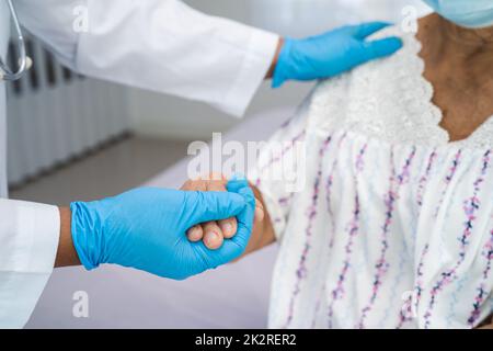 Doctor holding touching hands Asian senior or elderly old lady woman patient with love, care, helping, encourage and empathy at nursing hospital ward, healthy strong medical concept Stock Photo