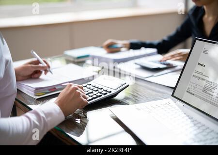 Businesspeople Calculating Invoice With Calculator Stock Photo