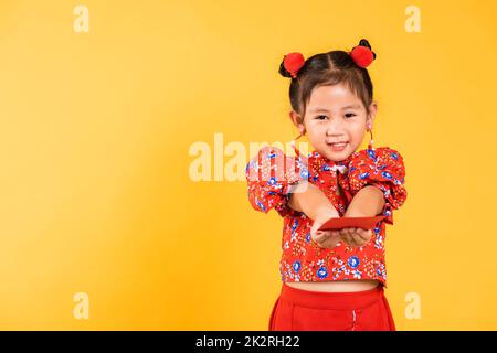 Happy Asian Chinese little girl smile wear red cheongsam handed angpao or red packet monetary gift Stock Photo