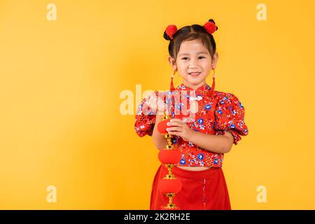 Happy Asian Chinese little girl smile wearing red cheongsam qipao holding silk lanterns Stock Photo