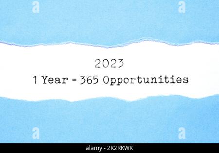 Inspirational quote 1 Year 2023 equal to 365 opportunities appearing behind torn blue paper. New beginning motivational concept. Stock Photo