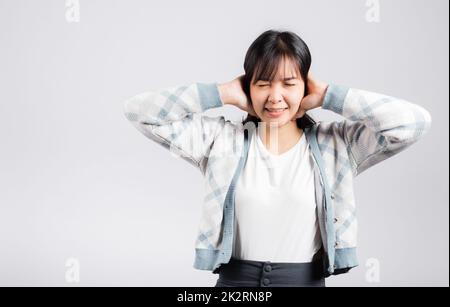 Woman bad mood pain her closed ears with hand palms and close eyes Stock Photo