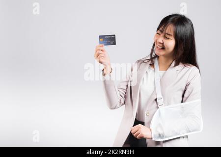 Woman confident smile broken arm after accident and wear arm splint for treatment she emergency pay medical bills by credit card Stock Photo