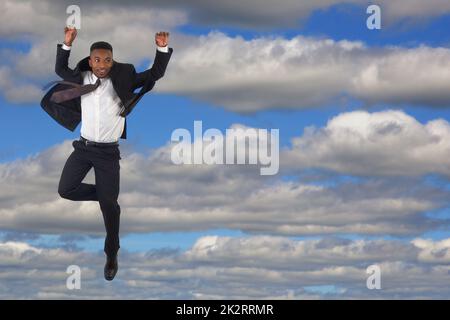 young businessman wearing suit and tie jumping into cloudy sky success and freedom life Stock Photo