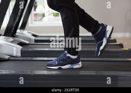 Jogging shoes for running on a treadmill. Safety when performing exercises on cardio in sports shoes. Side view Stock Photo