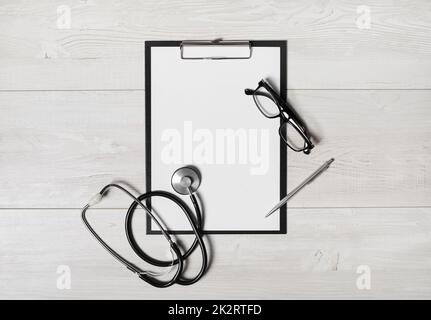 Doctor's medical supplies. Blank clipboard, stethoscope, glasses and pen. Flat lay. Stock Photo