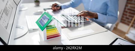 Businessman Calculating House Energy Cost Stock Photo