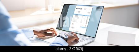 Businessman Using Laptop Preparing Invoice Stock Photo