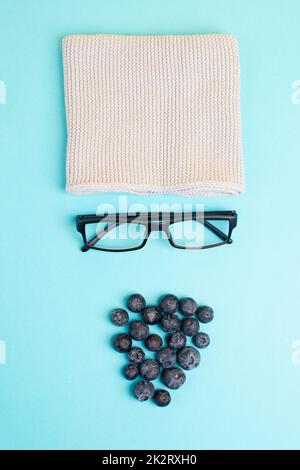 Human face made with a wool hat, glasses and blueberries as a beard, funny minimalist portrait, eco freak lifestyle, vegan food Stock Photo