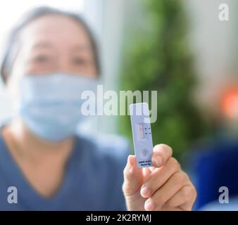 Senior Woman showing antigen self test card with negative result for  Covid-19 Stock Photo