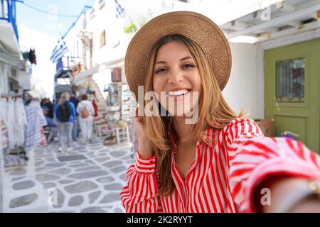 Self portrait of young woman with white smile strolling in Mykonos, Greece Stock Photo