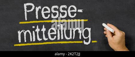 Text written on a blackboard - Press release in german - Pressemitteilung Stock Photo