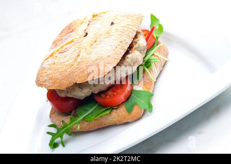 homemade turkey burger with cherry tomatoes and arugula in ciabatta Stock Photo
