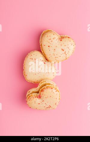 Heart shaped Sweet macarons on pink background. Stock Photo