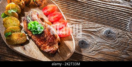 Pan-fried beef steak with fried potatoes and cherry tomatoes Stock Photo