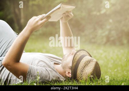 Man reading book in the park Stock Photo