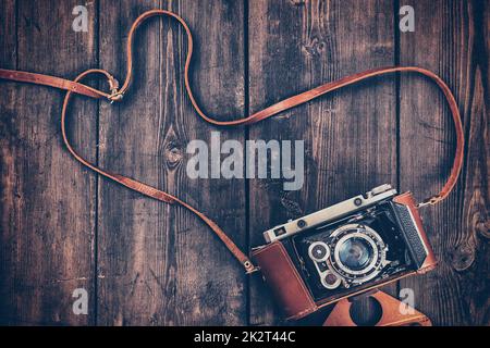 Old retro vintage camera on grunge wooden background Stock Photo