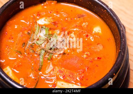 Korean traditional Kimchi Jjigae soup in bowl in the restaurant Stock Photo