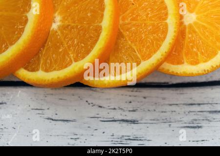 Large slices of orange on a wooden table Stock Photo