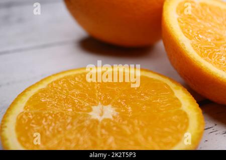 Close-up of slices and halves of oranges on a wooden table. Stock Photo