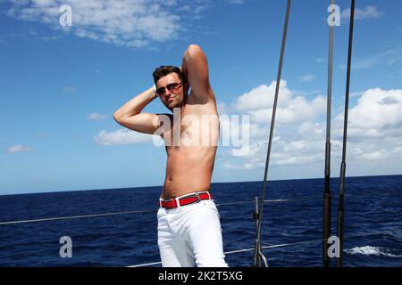Young man sailing his boat on the open ocean Stock Photo
