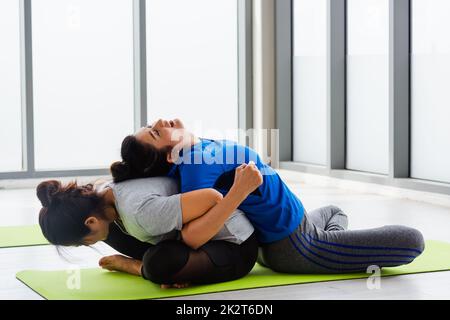 Two Asian women sporty attractive people practicing yoga lesson together Stock Photo