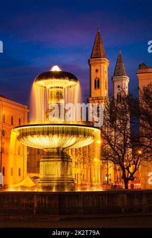 Fountain in the Geschwister-Scholl-Platz and St. Ludwig's Church Stock Photo