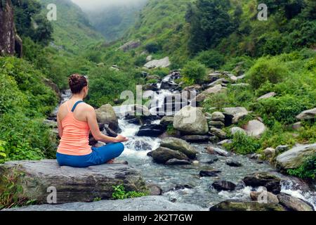 Woman doing yoga outdoors Stock Photo