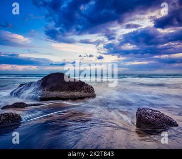 waves and rocks on beach of sunset Stock Photo